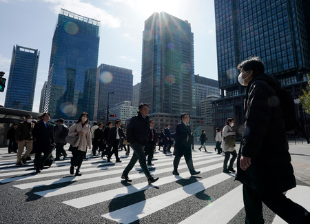 東京都内の横断歩道を渡る通勤客ら＝３月７日（ＥＰＡ時事）