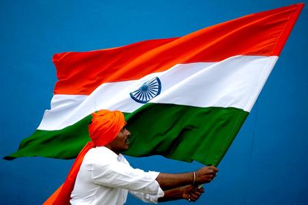 インドの国旗を持つインド人の男性＝２０１３年、バンガロール（ＥＰＡ時事）