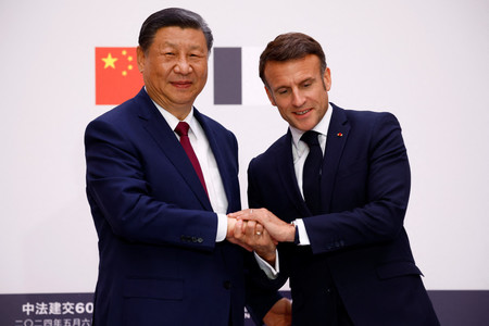 ６日、パリで握手する中国の習近平国家主席（左）とマクロン仏大統領（ＥＰＡ時事）