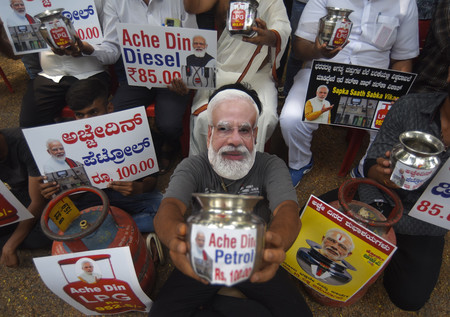 インドのモディ首相の仮面をかぶるなどし、同氏に抗議する人々＝４月２０日、南部ベンガルール（ＥＰＡ時事）