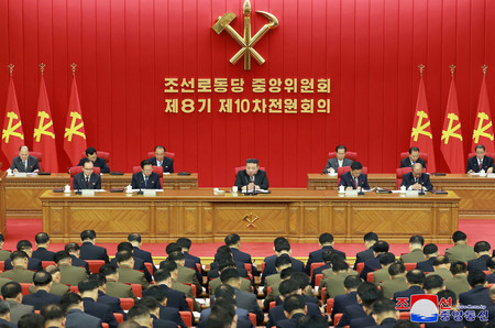 ２８日、朝鮮労働党中央委員会総会に参加する金正恩総書記（中央）（朝鮮通信・時事）