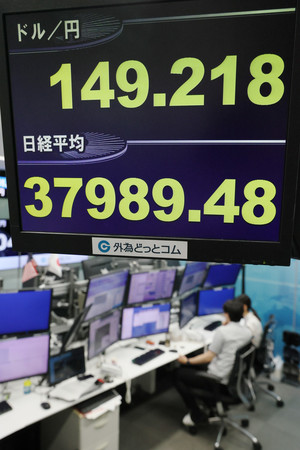 急騰した円相場と下落した日経平均株価を示すモニター＝１日午前、東京都港区の外為どっとコム