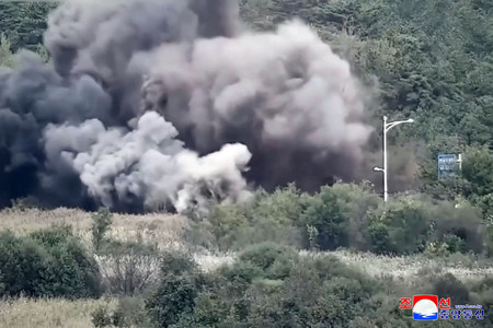 朝鮮中央通信が公開した北朝鮮が韓国につながる道路と鉄道を爆破する様子＝１５日、撮影場所不明（ＡＦＰ時事）