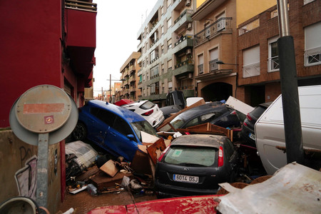 30日、スペイン東部バレンシア自治州で、洪水で流された路上の自動車(AFP時事)