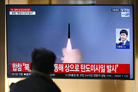 31日、ソウルの駅で、北朝鮮によるミサイル発射のニュースを見る男性(AFP時事)