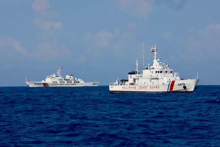 南シナ海上を接近して航海する中国海警局(左)とフィリピン沿岸警備隊の船=5月16日(EPA時事)