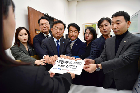 4日、ソウルの国会に尹錫悦大統領の弾劾訴追案を提出する野党議員ら(EPA時事)