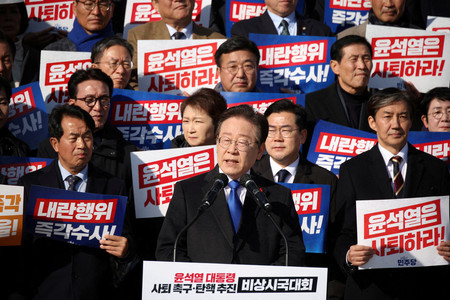 4日、ソウルで尹錫悦・韓国大統領を非難する集会に参加する革新系最大野党「共に民主党」の李在明代表(前列中央)ら(ロイター時事)