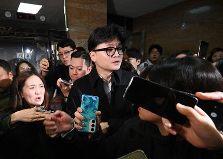 6日、ソウルの国会で記者団に囲まれる韓国与党「国民の力」の韓東勲代表(AFP時事)