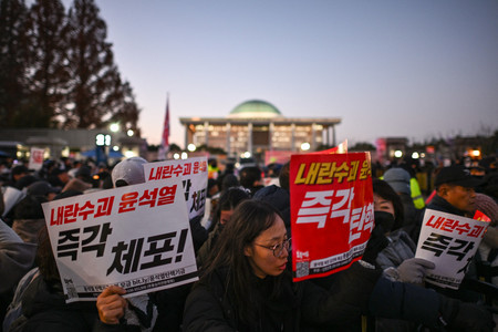 6日、ソウルの韓国国会の外で尹錫悦大統領の退陣を求めるデモ隊(AFP時事)