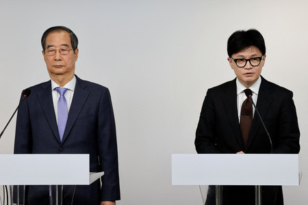 8日、ソウルで記者会見する韓国与党「国民の力」の韓東勲代表(右)と韓悳洙首相(ロイター時事)