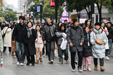 通りを歩く人たち＝２０２４年１２月、中国・湖北省武漢