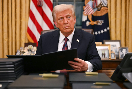 大統領執務室で多数の大統領令に署名するトランプ大統領=20日(AFP時事)