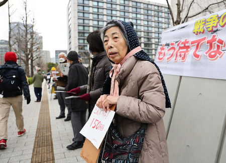 法整備を求めてチラシ配りをする全国空襲被害者連絡協議会の河合節子さん＝６日午後、東京都千代田区