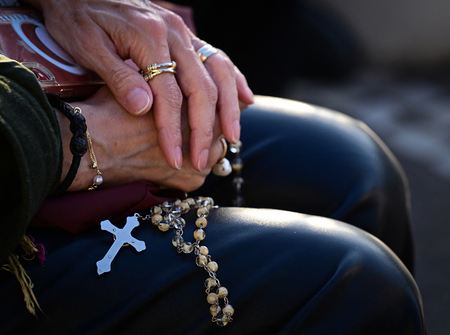 フランシスコ・ローマ教皇が入院している病院の外で、ロザリオを手に祈る女性＝６日、ローマ（ＡＦＰ時事）