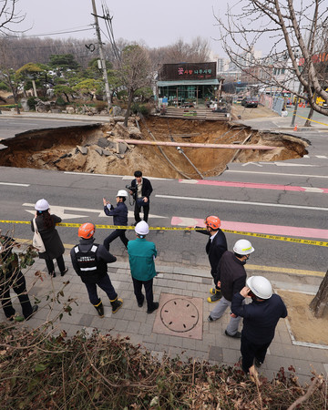 25日、ソウル市江東区の交差点で陥没した道路(EPA時事)