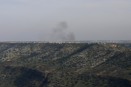 25日、イスラエル軍の砲撃を受けてシリア南部で上がる煙(AFP時事)
