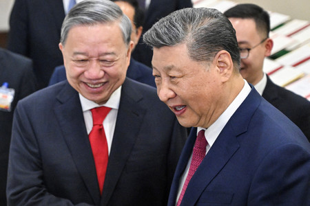 14日、ハノイで調印された2国間の協力文書を見る中国の習近平国家主席(右)とベトナムの最高指導者トー・ラム共産党書記長(AFP時事)