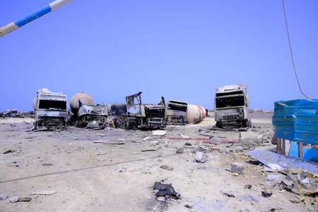米軍による空爆で焼けた車両=18日、イエメン・ラスイッサ港付近(AFP時事)