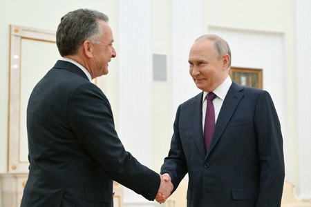 25日、モスクワで会談に先立ち握手するロシアのプーチン大統領(右)とウィトコフ米中東担当特使(AFP時事)