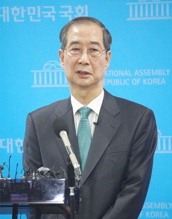 2日、ソウルの韓国国会で記者団の取材に応じる韓悳洙前首相