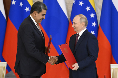 7日、モスクワのクレムリン(大統領府)で握手するロシアのプーチン大統領(右)とベネズエラのマドゥロ大統領(AFP時事)