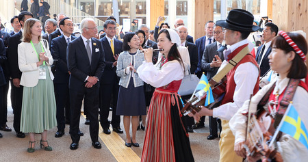 14日、大阪・関西万博会場で開かれたスウェーデンの「ナショナルデーパレード」の出発を見送るカール16世グスタフ国王(前列左から2人目)、三笠宮家の彬子さま(同3人目)ら=大阪市此花区