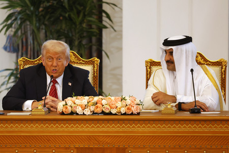 14日、ドーハで署名式に臨むトランプ米大統領(左)とカタールのタミム首長(AFP時事)