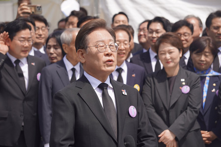 18日、韓国南西部・光州市の国立墓地で、光州事件の記念式典に出席した後、記者団の取材に応じる革新系最大野党「共に民主党」の李在明前代表