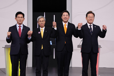18日、ソウルで開かれた韓国大統領選のテレビ討論会に臨む革新系最大野党「共に民主党」の李在明前代表(右端)、保守系野党「改革新党」の李俊錫議員(右から2人目)、保守系与党「国民の力」の金文洙前雇用労働相(左端)(AFP時事)