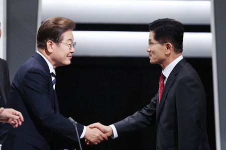 韓国大統領選の保守系与党「国民の力」候補の金文洙前雇用労働相(右)と革新系最大野党「共に民主党」候補の李在明前代表=23日、ソウル(AFP時事)