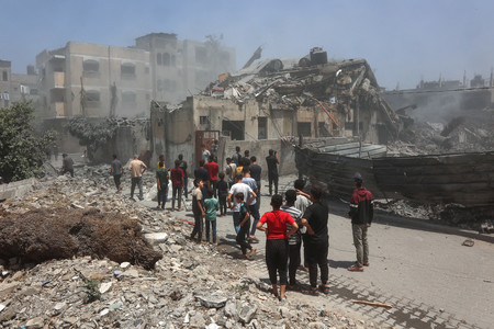 ５月３１日、パレスチナ自治区ガザ北部ガザ市で、イスラエル軍の攻撃を受けた建物を調べる人々（ＡＦＰ時事）