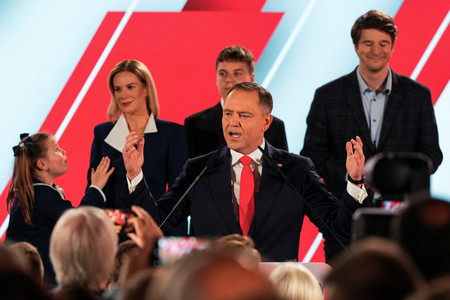 １日、ワルシャワで、ポーランド大統領選決選投票の出口調査の結果を受けて演説するナブロツキ氏（中央）（ロイター時事）