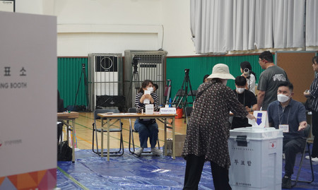 ３日、ソウル市内の投票所で、韓国大統領選の票を投じる有権者
