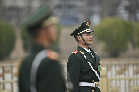中国・北京の人民大会堂を警備する警察官＝３月１１日（ＡＦＰ時事）