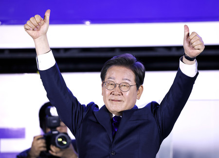 4日未明、ソウルの韓国国会前で拳を突き上げる革新系政党「共に民主党」の李在明氏(EPA時事)