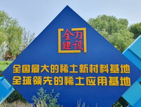 レアアースを生かしたまちの建設を訴える看板=2024年7月、中国・内モンゴル自治区包頭市
