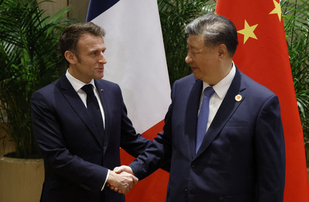 握手するフランスのマクロン大統領(左)と中国の習近平国家主席=2024年11月、ブラジル・リオデジャネイロ(AFP時事)