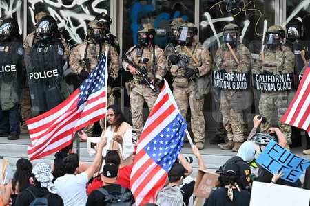 10日、米ロサンゼルス市内の連邦ビルを警備するカリフォルニア州兵と警察官(AFP時事)