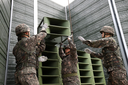 南北軍事境界線付近で拡声器を撤去する韓国軍の兵士=2018年5月、京畿道坡州市(EPA時事)