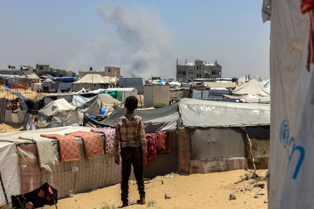11日、パレスチナ自治区ガザ最南部ラファで、イスラエル軍の爆撃中に上がる煙(AFP時事)