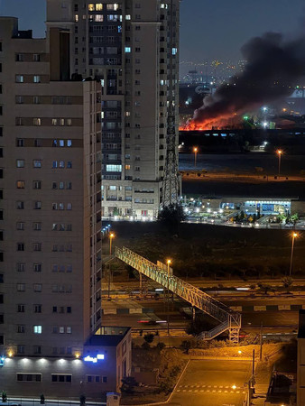 13日、イスラエルの攻撃で炎上するイランの首都テヘランの建物=革命防衛隊のSNSより(AFP時事)