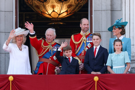 14日、ロンドンのバッキンガム宮殿で、チャールズ英国王の「公式誕生日」を祝うパレードを見守る国王夫妻ら王族(ロイター時事)