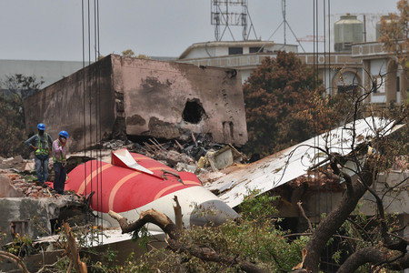 14日、インド西部アーメダバードで、墜落した旅客機の残骸の撤去に当たる軍当局者ら(ロイター時事)