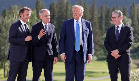 写真撮影の間、各国首脳と歓談するトランプ米大統領(右から2人目)=16日、カナダ・カナナスキス(EPA時事)
