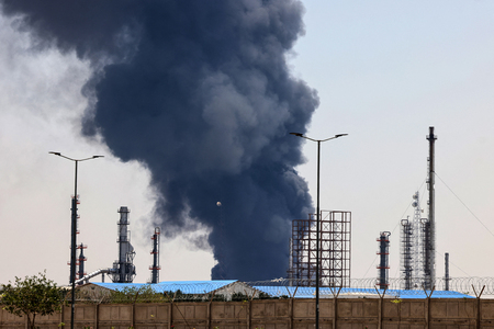 イスラエルの攻撃を受け、煙と炎を上げるイランの石油精製施設＝１５日、テヘラン南部（ＡＦＰ時事）