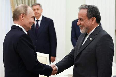 ２３日、モスクワのクレムリン（ロシア大統領府）で握手するプーチン大統領（左）とイランのアラグチ外相（ＡＦＰ時事）