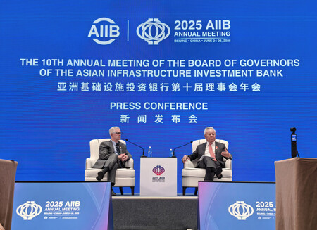 年次総会に合わせて記者会見するアジアインフラ投資銀行（ＡＩＩＢ）の金立群総裁（右）＝２６日、北京