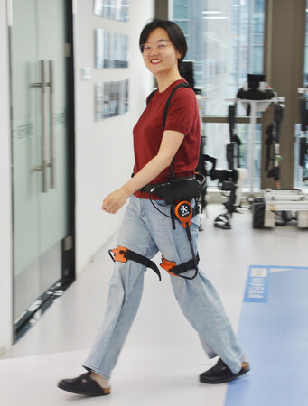 程天科技の登山支援ロボットを装着して歩く女性＝６月２４日、中国浙江省杭州市