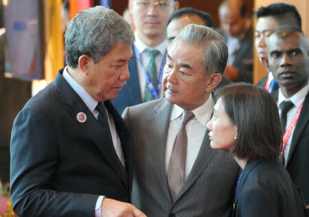 東南アジア諸国連合(ASEAN)関連会議に出席後、マレーシアのモハマド外相(左)と話す中国の王毅共産党政治局員兼外相(中央)=10日、クアラルンプール
